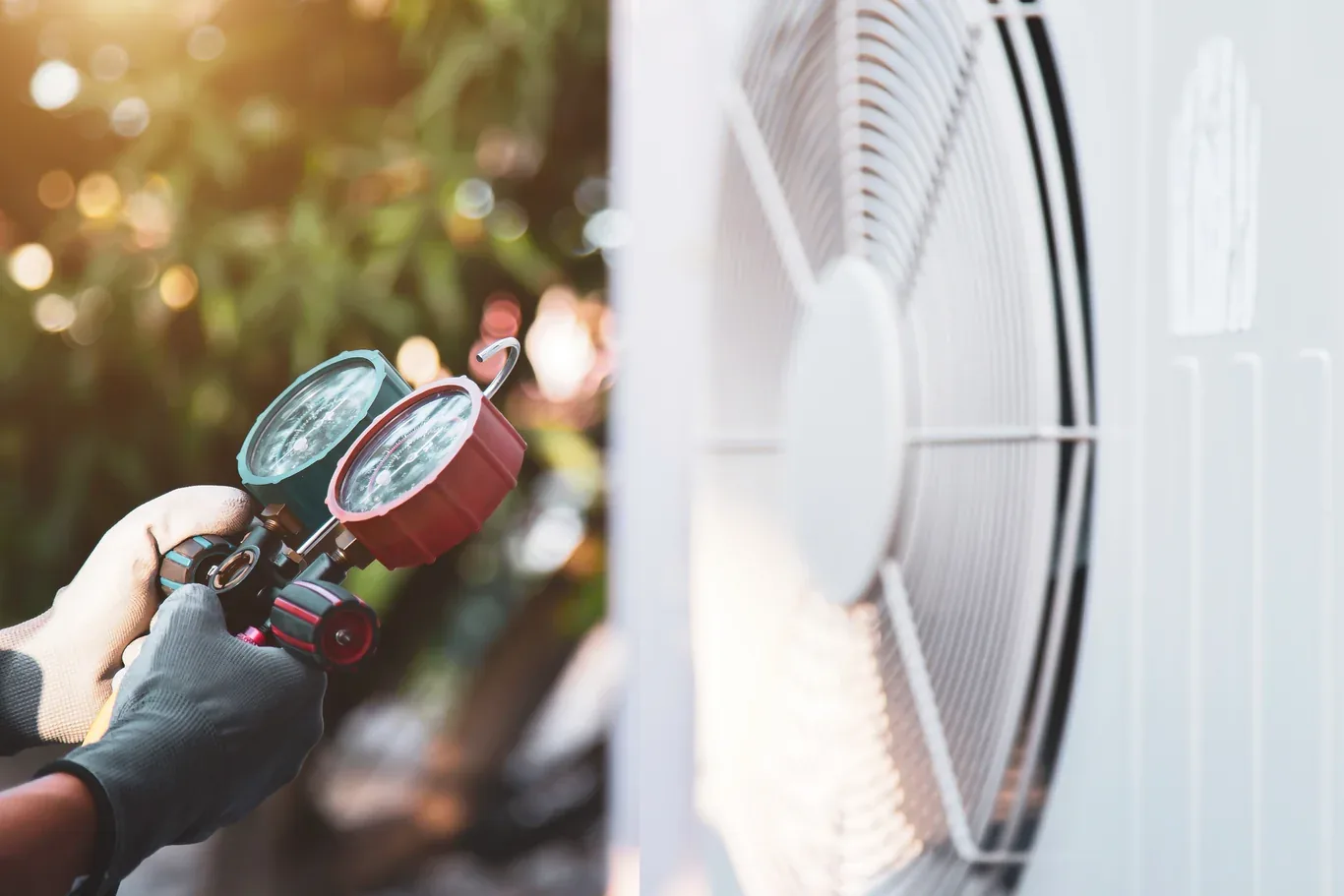 Technician measuring refrigerant with manifold gauges on an air conditioner